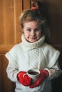 Cute blonde little girl holding hot steaming tea cup close up photo Royalty Free Stock Photo