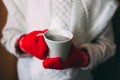 Cute blonde little girl holding hot steaming tea cup close up photo Royalty Free Stock Photo