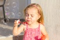 A cute blonde little gir, blowing soap bubbles Royalty Free Stock Photo