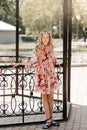 Smiling blonde teen girl posing in summer garden. Wearing flower wreath outdoors Royalty Free Stock Photo