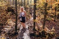 Cute blonde woman hiker wearing a tank top hikes the Bean and Bear Loop along the Superior Hiking Trail in Minnesota during fall