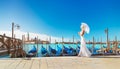 Cute blonde woman in white dress with umbrella walking in Venice against panoramic view of Gondolas at their moorings, famous San Royalty Free Stock Photo