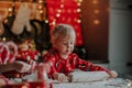 Cute blondie little girl roll out the dough for Christmas cookies