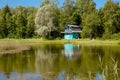 Cute blue color tiny house home by lake in summer.