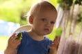 Cute blue-eyed baby boy eating cucumber Royalty Free Stock Photo