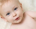 Cute blue eyed baby laying on a fluffy rug Royalty Free Stock Photo