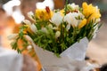 cute bouquet of natural white and yellow flowers in white paper, blurred background Royalty Free Stock Photo