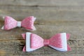 Cute bows for hair. Pink and white shiny felt bows clips for little girls. Nice hair accessories on a wooden background Royalty Free Stock Photo