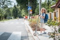Boy with a backpack and scooter is standing in front of a pedestrian crossing on the street Royalty Free Stock Photo