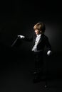 Cute boy in black tuxedo and white gloves