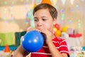 Cute boy blowing balloon during birthday party Royalty Free Stock Photo