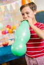 Cute boy blowing balloon during birthday party Royalty Free Stock Photo