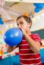 Cute boy blowing balloon during birthday party Royalty Free Stock Photo