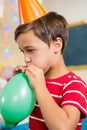 Cute boy blowing balloon during birthday party Royalty Free Stock Photo