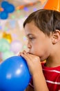 Cute boy blowing balloon during birthday party Royalty Free Stock Photo