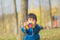 Cute boy in blue sportswear playing with toys in the woods Royalty Free Stock Photo