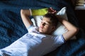 Cute boy with broken hand relaxing and smiling on couch. Close up young handsome Teenage with elbow plaster Royalty Free Stock Photo