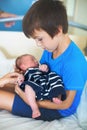 Cute boy, brother, meeting for the first time his new baby broth Royalty Free Stock Photo