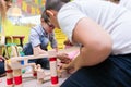 Cute boy building with attention and patience a wooden structure