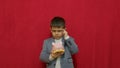 Cute boy in business suit holding piggy bank and getting an idea how to earn more money. Steals the piggy bank. Royalty Free Stock Photo