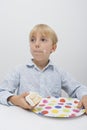 Cute boy with cake slice in plate on table looking away at home Royalty Free Stock Photo