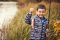 Cute boy catches fish on a summer lake Royalty Free Stock Photo