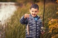 Cute boy catches fish on a summer lake Royalty Free Stock Photo