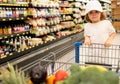 Cute boy child with shopping trolley with products. Funny child with shopping trolley with in grocery store.