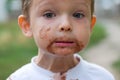 Cute boy with chocolate ice cream on face. Kid with a dirty face after he ate icecream Royalty Free Stock Photo