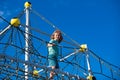 Cute boy climbing net in the park and having fun on the playground. Royalty Free Stock Photo