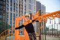 Cute boy is climbing on the playground in the schoolyard. He has a very happy face and enjoy this adventure sports alone outdoor. Royalty Free Stock Photo