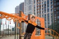 Cute boy is climbing on the playground in the schoolyard. He has a very happy face and enjoy this adventure sports alone outdoor. Royalty Free Stock Photo