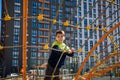 Cute boy is climbing on the playground in the schoolyard. He has a very happy face and enjoy this adventure sports alone outdoor. Royalty Free Stock Photo