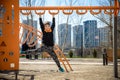 Cute boy is climbing on the playground in the schoolyard. He has a very happy face and enjoy this adventure sports alone outdoor. Royalty Free Stock Photo