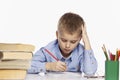 Cute boy does homework at the table, white background Royalty Free Stock Photo