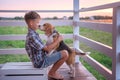 Cute boy and dog Beagle sitting hugging on the veranda Royalty Free Stock Photo