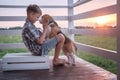 Cute boy and dog Beagle sitting hugging on the veranda Royalty Free Stock Photo