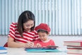 Cute boy doing his school homework with his mother, at home, he Royalty Free Stock Photo