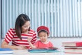 Cute boy doing his school homework with his mother, at home, he Royalty Free Stock Photo