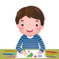 Cute boy drawing with colourful pencils