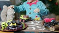 Cute boy dressed as elf petting his soft toy squirrel and assembling toys in santa's workshop Royalty Free Stock Photo