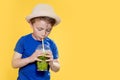 Cute boy Drink Mojito cocktail From Plastic Cup Over Yellow Studio Background Royalty Free Stock Photo