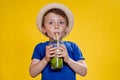 Cute boy Drink Mojito cocktail From Plastic Cup Over Yellow Studio Background Royalty Free Stock Photo