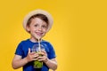 Cute boy Drink Mojito cocktail From Plastic Cup Over Yellow Studio Background Royalty Free Stock Photo