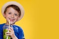 Cute boy Drink Mojito cocktail From Plastic Cup Over Yellow Studio Background Royalty Free Stock Photo