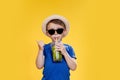 Cute boy Drink Mojito cocktail From Plastic Cup Over Yellow Studio Background Royalty Free Stock Photo