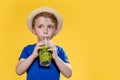 Cute boy Drink Mojito cocktail From Plastic Cup Over Yellow Studio Background Royalty Free Stock Photo