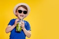 Cute boy Drink Mojito cocktail From Plastic Cup Over Yellow Studio Background Royalty Free Stock Photo