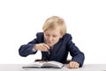 Cute boy first grader in school uniform fooling around while sitting at his desk. Schoolboy plays and makes face while doing