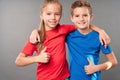 Cute boy and girl hugging and giving thumbs up